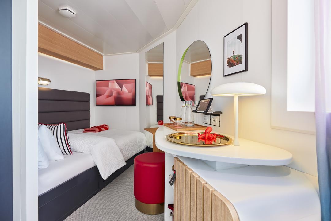 Virgin Voyages Solo Sea View cabin with single bed, vanity workspace and bright, airy lighting