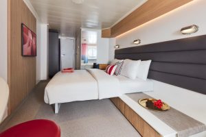 Virgin Voyages Sea View cabin modern double bed layout with overhead shelf and soft lighting