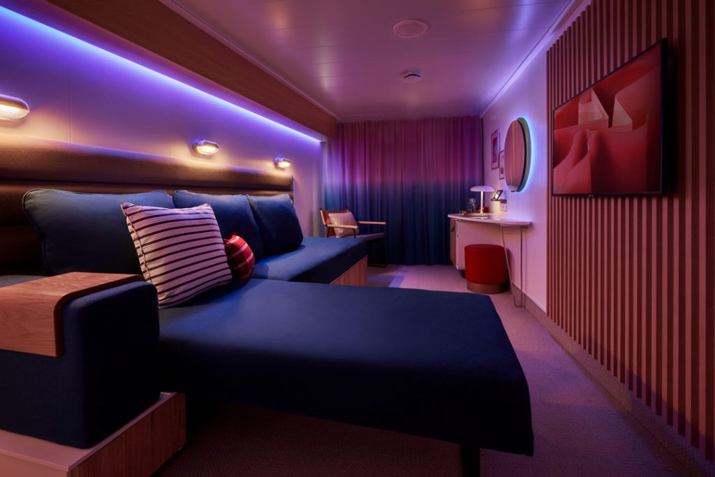 Sea Terrace cabin at night with mood lighting, sofa-bed and ambient purple glow