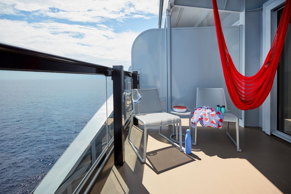 IMG SCL 2021 CAB sea terrace xl interior balcony day 2 UNCROPPED Red hammock on Sea Terrace balcony overlooking the ocean | Virgin Voyages Black Friday deals